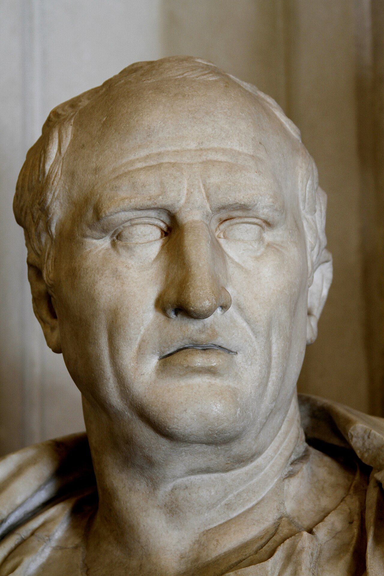 Marble bust of a heavy-jowled man with short hair and a furrowed brow