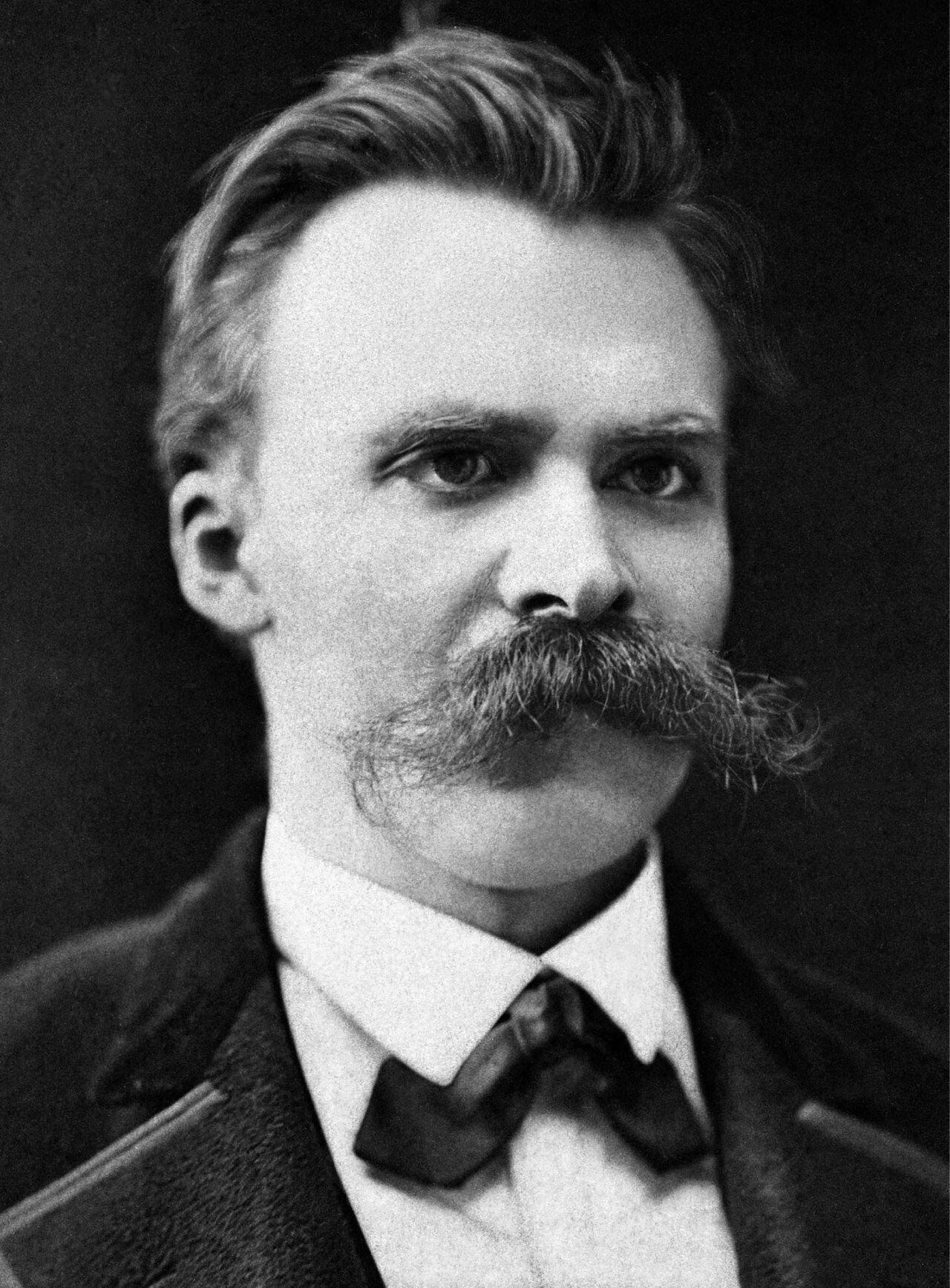 Photograph of a man with a large moustache in a dark suit and bow tie