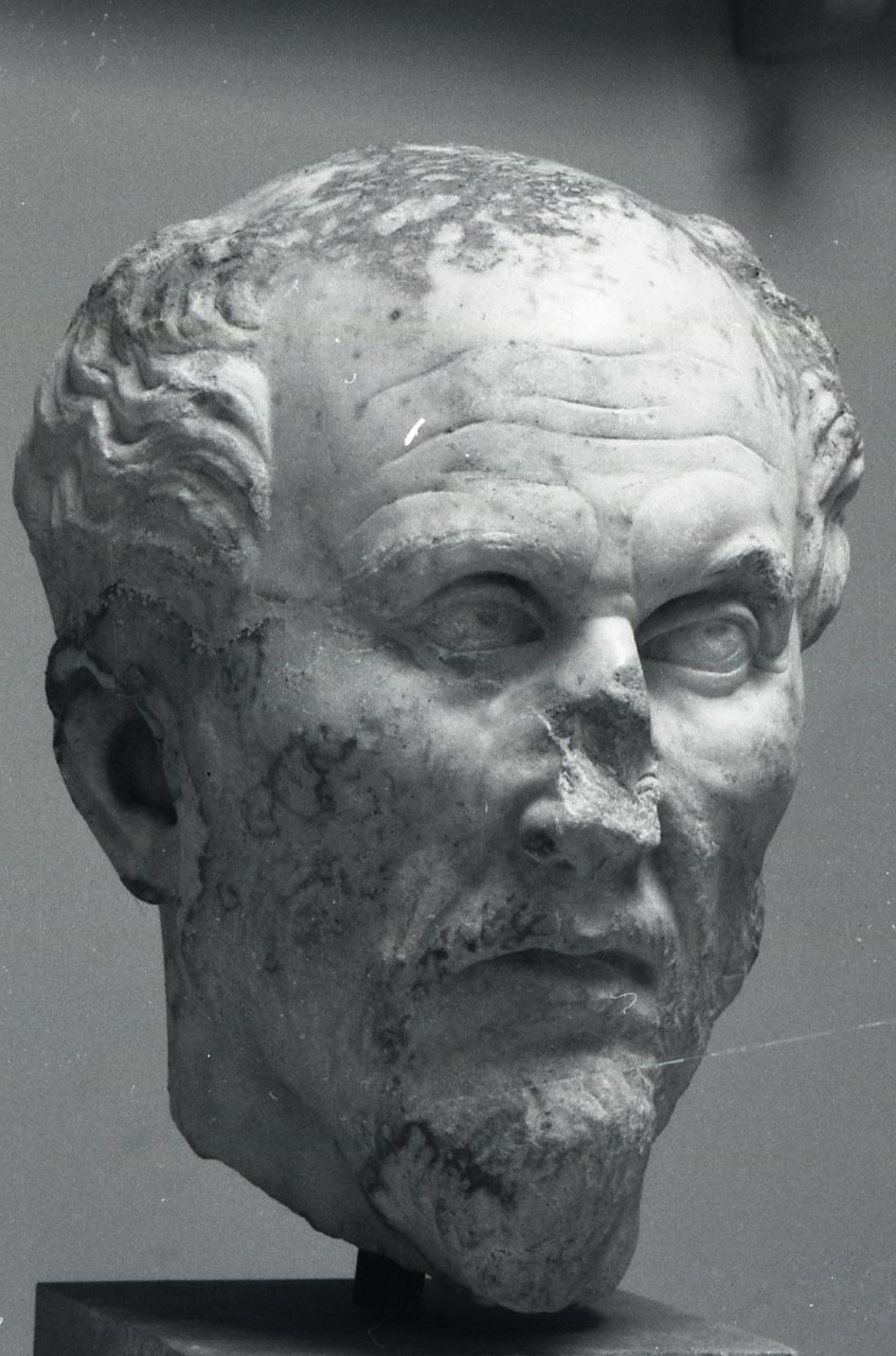 Damaged marble head of an older, bearded man