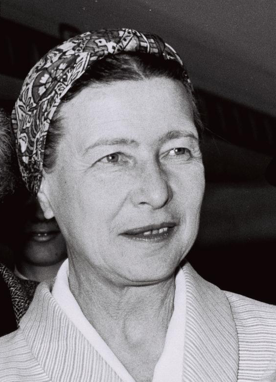 Photograph of a smiling older woman with her hair wrapped in a patterned scarf