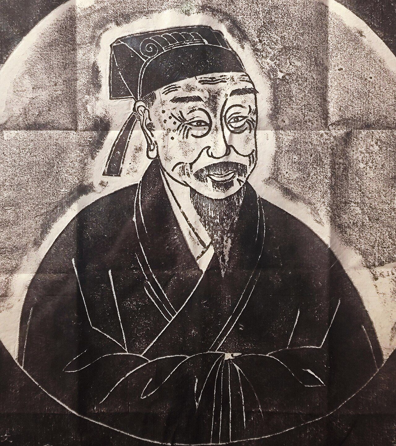 Ink rubbing of an elderly man in a scholar’s cap, with a thin beard and moles beside one eye